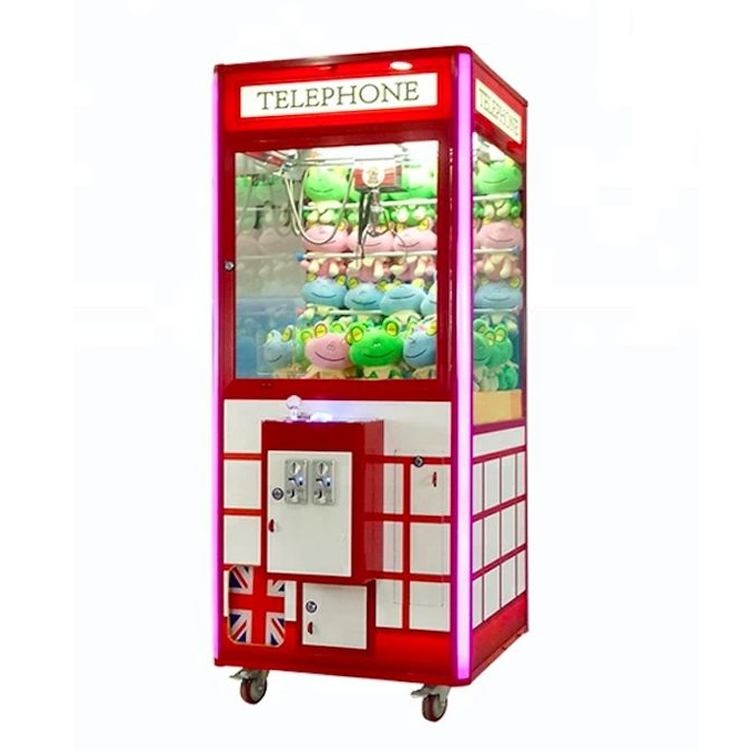 Phone booth style claw machine with colorful stuffed toys inside, attracting players with its vintage design